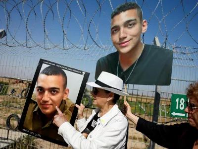 FILE PHOTO: Varda Ben Baruch, grandmother of hostage Edan Alexander, points at the portrait of Edan, as family members and supporters of hostages who were kidnapped during the deadly October 7 attack, stand near the kibbutz defence on the day they use giant loudspeakers to call their captive loved ones over the border between Israel and Gaza, at Kibbutz Nir Oz, in southern Israel, April 20, 2025. REUTERS/Amir Cohen/File Photo
