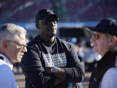 FILE - Michael Jordan, center, and Curtis Polk, left, co-owners of 23XI Racing, watch during qualifying beside 23XI Racing President Steve Lauletta, right, for a NASCAR Cup Series Championship auto race, Nov. 9, 2024, in Avondale, Ariz. (AP Photo/John Locher, file)