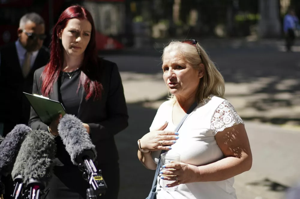 Kim Smith, sister of Peter Sullivan, with lawyer Sarah Myatt, left, speaks to the media outside the Royal Courts of Justice, London, Tuesday May 13, 2025, after Peter Sullivan who spent 38 years in a British prison had his murder conviction overturned. (Ben Whitley/PA via AP)