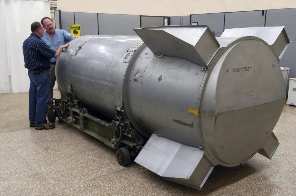 Workers examine a B53 nuclear bomb at the B&W Pantex nuclear weapons storage facility outside Amarillo, Texas, in this handout photograph taken and released on October 25, 2011. The United States dismantled the oldest nuclear bomb in its Cold War arsenal -- and one of the most powerful it ever built -- on Tuesday as part of President Barack Obama's nuclear security policy. Built at the height of the Cold War in 1962, the bomb was designed to be dropped onto a target by a massive B-52 Stratofortress strategic bomber. REUTERS/Photo Courtesy B&W Pantex/Handout (UNITED STATES - Tags: MILITARY SCIENCE TECHNOLOGY) FOR EDITORIAL USE ONLY. NOT FOR SALE FOR MARKETING OR ADVERTISING CAMPAIGNS. THIS IMAGE HAS BEEN SUPPLIED BY A THIRD PARTY. IT IS DISTRIBUTED, EXACTLY AS RECEIVED BY REUTERS, AS A SERVICE TO CLIENTS