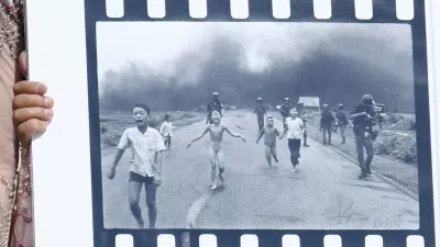 Pulitzer Prize-winning photographer Nick Ut (R), flanked by Kim Phuc, known as the 'Napalm Girl', shows his 1972 Vietnam war iconic photo as they wait to meet Pope Francis at the end of the weekly general audience in St. Peter s Square, Vatican on May 11, 2022.