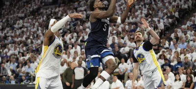 Minnesota Timberwolves guard Anthony Edwards (5) looks to shoot against Golden State Warriors' Pat Spencer, right, and Buddy Hield, left, during the second half of Game 5 of an NBA basketball second-round playoff series, Wednesday, May 14, 2025, in Minneapolis. (AP Photo/Abbie Parr)