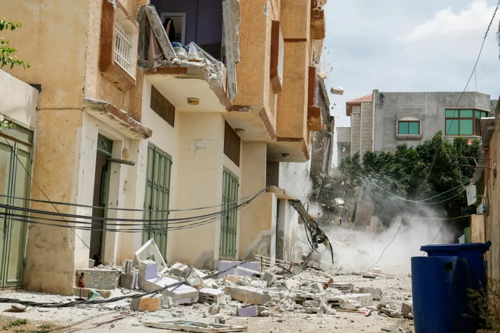 An Israeli heavy machinery demolishes a building, during an Israeli raid in Tammoun, near Tubas, in the Israeli-occupied West Bank, May 15, 2025. REUTERS/Raneen Sawafta