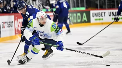 Finland's Mikael Ruohomaa, left, and Slovenia's Bine Masic, right, challenge for the puck during the IIHF Ice Hockey World Championship group A match between Finland and Slovenia in Stockholm, Sweden, Thursday, May 15, 2025. (Anders Wiklund/TT News Agency via AP)