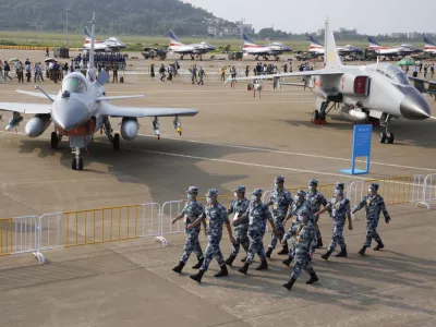 Chinese Air Force personnel march past the Chinese military's J10C fighter and JH-7A2 fighter bomber during 13th China International Aviation and Aerospace Exhibition, also known as Airshow China 2021, Wednesday, Sept. 29, 2021, in Zhuhai in southern China's Guangdong province. With record numbers of military flights near Taiwan over the last week, China has been stepping up its harassment of the island it claims as its own, showing an new intensity and sophistication as it asserts its territorial claims in the region. (AP Photo/Ng Han Guan)