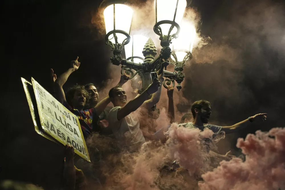 Barcelona fans celebrate in the street after their team won the Spanish La Liga soccer championship in Barcelona, Spain, Thursday, May 15, 2025. (AP Photo/Emilio Morenatti)