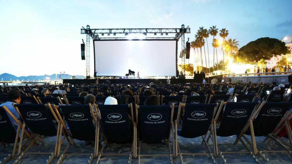 People sit ahead of a beach front cinema screening during the 78th Cannes Film Festival in Cannes, France, May 15, 2025. REUTERS/Stephane Mahe