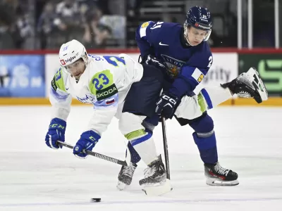Slovenia's Jaka Sodja, left, and Finland's Patrik Puistola, right, challenge for the puck during the IIHF Ice Hockey World Championship group A match between Finland and Slovenia in Stockholm, Sweden, Thursday, May 15, 2025. (Anders Wiklund/TT News Agency via AP)
