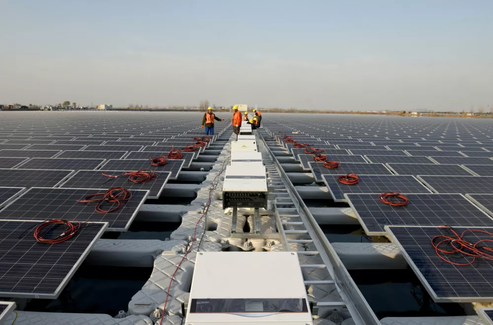 Workers install solar panels at a floating solar plant developed by China's Three Gorges Group, in Huainan, Anhui province, China December 11, 2017. Picture taken December 11, 2017. REUTERS/Stringer ATTENTION EDITORS - THIS IMAGE WAS PROVIDED BY A THIRD PARTY. CHINA OUT.