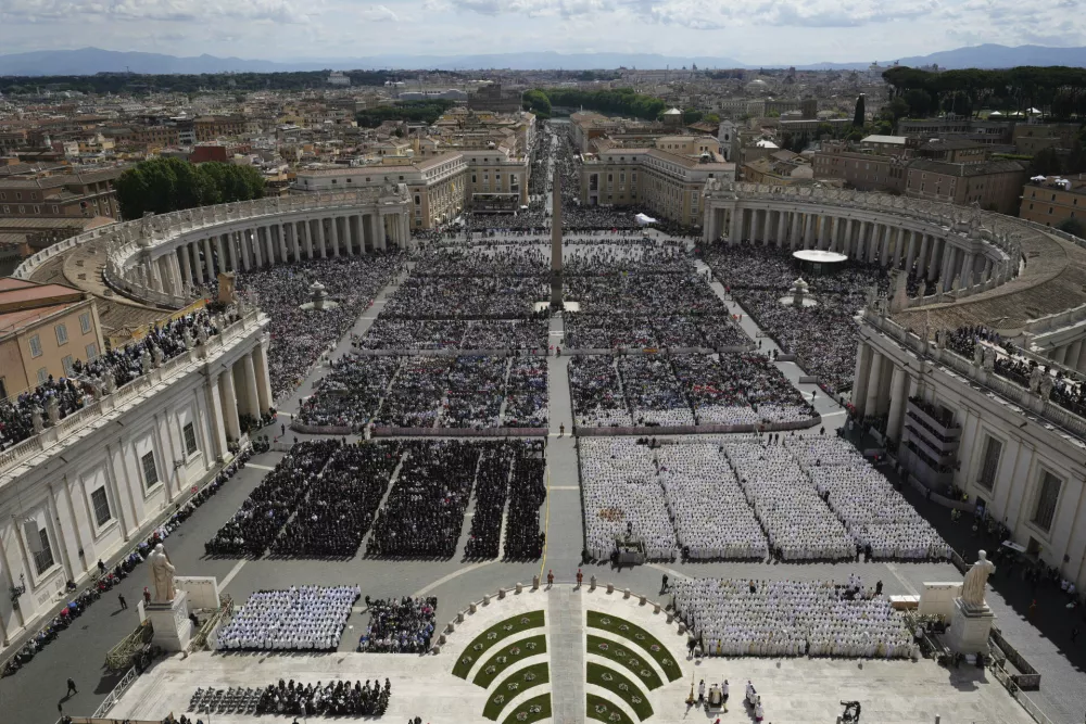 People gather as Pope Leo XIV celebrates a Mass for the formal inauguration of his pontificate, in St. Peter's Square, at the Vatican, Sunday, May 18, 2025. (AP Photo/Alessandra Tarantino)