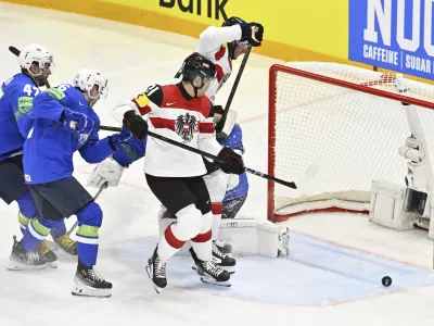 Austria's Lukas Haudum, center, in action during the IIHF Ice Hockey World Championship group A match between Slovenia and Austria at Avicii Arena in Stockholm, Sweden, Sunday May 18, 2025. (Anders Wiklund/TT News Agency via AP)