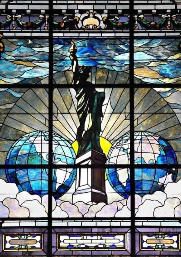 Svoboda razsvetljuje svet ali Kip svobode, vitraž, ki ga je naročil Joseph Pulitzer v spomin na zbiranje sredstev pri časopisni hi&scaron;i New York World za podstavek Kipa svobode. Prvotno je bil vitraž name&scaron;čen v stavbi New York World Building, nato pa so ga prestavili v Pulitzerjevo dvorano na Univerzo Columbia. / Foto: Wikipedija