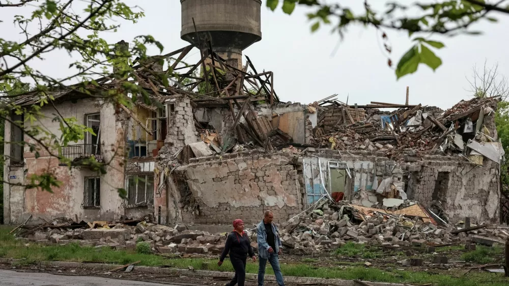 Residents walk at a street near buildings damaged by Russian military strikes, amid Russia's attack on Ukraine, in the frontline town of Myrnohrad, Donetsk region, Ukraine May 29, 2025. REUTERS/Anatolii Stepanov / Foto: Anatolii Stepanov