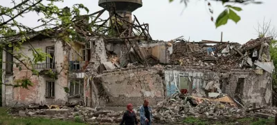 Residents walk at a street near buildings damaged by Russian military strikes, amid Russia's attack on Ukraine, in the frontline town of Myrnohrad, Donetsk region, Ukraine May 29, 2025. REUTERS/Anatolii Stepanov / Foto: Anatolii Stepanov