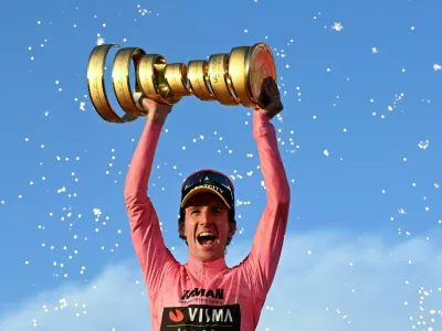 Cycling - Giro d'Italia - Stage 21 - Rome to Rome - Italy - June 1, 2025 Team Visma | Lease a Bike's Simon Yates celebrates with a trophy on the podium after winning the Giro d'Italia REUTERS/Jennifer Lorenzini  TPX IMAGES OF THE DAY / Foto: Jennifer Lorenzini