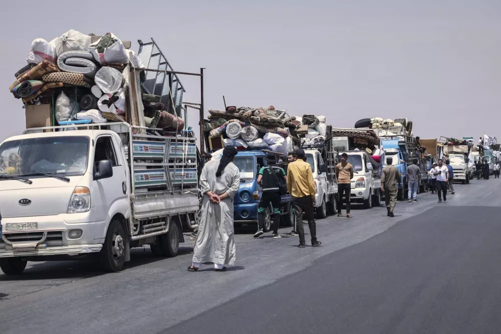 Trucks carrying around 60 displaced families gather on the highway as they head to their village, Kafr Sijna, after more than five years in the Atmeh camps near the Syrian-Turkish border, on a highway north of Kafr Sijna, Syria, Sunday, May 18, 2025. (AP Photo/Ghaith Alsayed)
