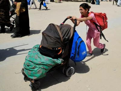 A girl pushes a stroller with belongings as Palestinians flee their homes after the Israeli military issued orders for evacuation from eastern Khan Younis, in the southern Gaza Strip, May 19, 2025. REUTERS/Hatem Khaled   TPX IMAGES OF THE DAY