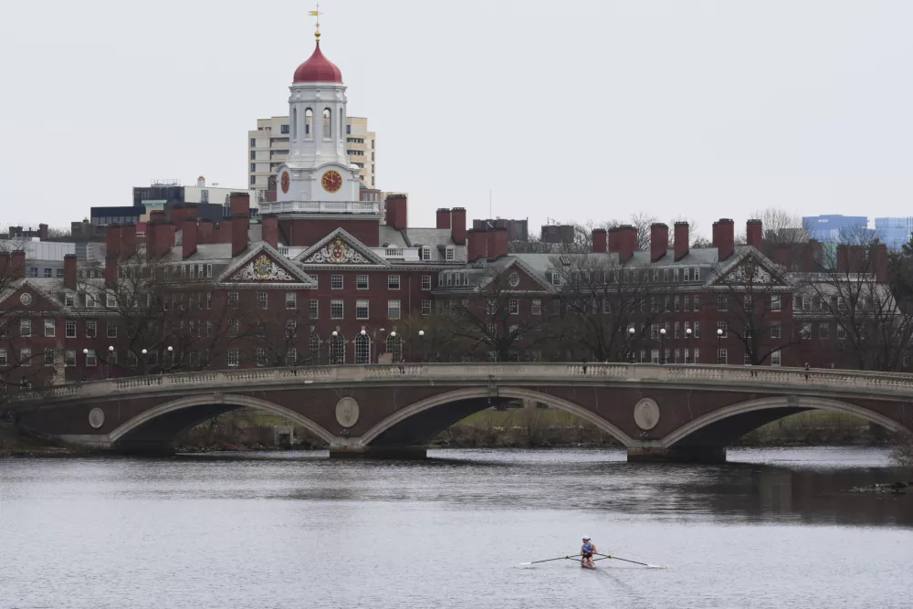 FILE - A sculler rows down the Charles River near Harvard University, at rear, April 15, 2025, in Cambridge, Mass. (AP Photo/Charles Krupa, File)