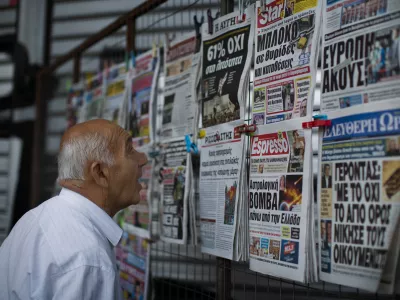 A man looks at the newspapers at a newsstand in central Athens, Monday, July 6, 2015. Greece's finance minister has resigned following Sunday's referendum in which the majority of voters said "no" to more austerity measures in exchange for another financial bailout. (AP Photo/Emilio Morenatti)