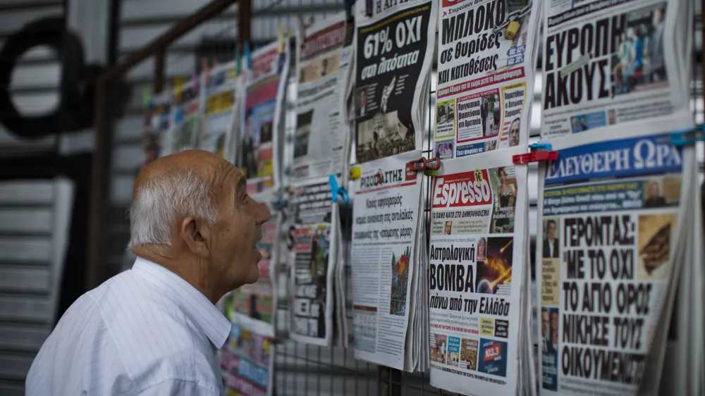 A man looks at the newspapers at a newsstand in central Athens, Monday, July 6, 2015. Greece's finance minister has resigned following Sunday's referendum in which the majority of voters said "no" to more austerity measures in exchange for another financial bailout. (AP Photo/Emilio Morenatti)