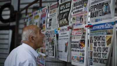 A man looks at the newspapers at a newsstand in central Athens, Monday, July 6, 2015. Greece's finance minister has resigned following Sunday's referendum in which the majority of voters said "no" to more austerity measures in exchange for another financial bailout. (AP Photo/Emilio Morenatti)