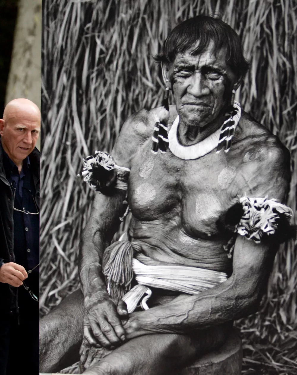 FILE PHOTO: Brazilian documentary photographer Sebastiao Salgado poses with one of his photographs exhibited in Oviedo, northern Spain, October 19, 2006. REUTERS/Eloy Alonso/File Photo