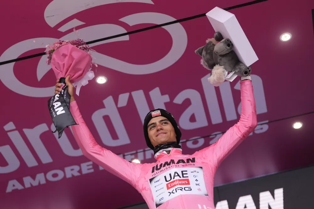 Mexico's Isaac Del Toro wears the pink jersey of the race overall leader as he celebrates on the podium after winning the 14th stage of the Giro d'Italia cycling race from Treviso to Nova Gorica/Gorizia, Italy, Saturday, May 24, 2025. (Fabio Ferrari/LaPresse via AP)