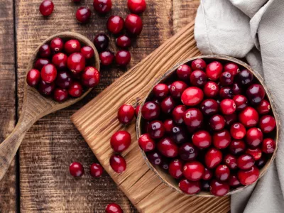 Ripe cranberry in wooden bowl on wooden table. / Foto: Gitusik