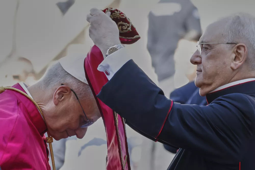 Pope Leo XIV is helped by Monsignor Leonardo Sapienza to wear a stole at the foot of Capitoline Hill, in Rome, Sunday, May 25, 2025. (AP Photo/Riccardo De Luca)