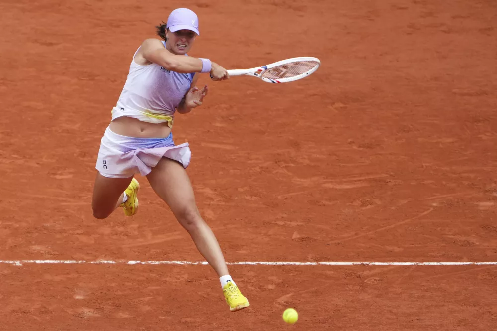 Poland's Iga Swiatek hits a forehand against Slovakia's Rebecca Sramkova during their first round match of the French Tennis Open, at the Roland-Garros stadium, in Paris, Monday, May 26, 2025. (AP Photo/Lindsey Wasson)