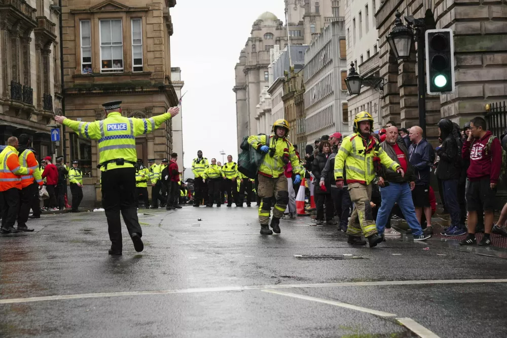 Police and emergency personnel deal with an incident on Water Street near the Liver Building in Liverpool after a car collided with pedestrians during the Premier League winners parade, in Liverpool, England, Monday May 26, 2025. (Owen Humphreys/PA via AP)