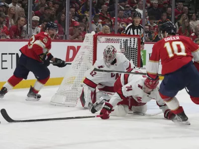 Carolina Hurricanes defenseman Jaccob Slavin (74) goes for the puck against Florida Panthers left wing A.J. Greer (10) during the second period in Game 3 of the NHL hockey Stanley Cup Eastern Conference finals Saturday, May 24, 2025, in Sunrise, Fla. (AP Photo/Lynne Sladky)
