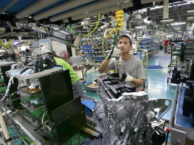 In this Aug. 2, 2017, photo, Nissan Motor Co. factory workers check engines on an assembly line at its plant in Yokohama, near Tokyo. Aiming to get an edge on its rivals in an intensely competitive industry, Japanese automaker Nissan says it&acirc;&euro;&trade;s attempting to foster a corporate culture that will produce manufacturing innovations in leaps and bounds instead of steady incremental improvement. Its discussion of that effort is partly a swipe at bigger competitor Toyota Motor Corp. which for decades has favored the concept of &acirc;&euro;śkaizen&acirc;&euro;ť or fine tuning and bit-by-bit progress in auto manufacturing. (AP Photo/Shizuo Kambayashi)