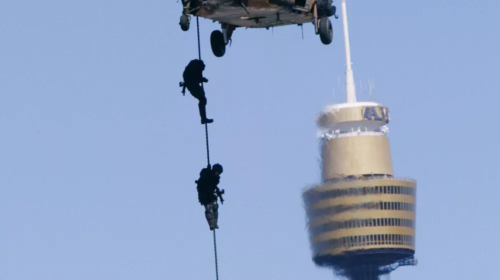 Commandos repel down a rope from one of two Black Hawk helicopters with Sydney's landmark building Center Point Tower behind during a counter terrorism exercise in Sydney, Australia, Sunday, Sept. 28, 2003. The Australian Defense Force held its biggest counter-terrorism exercise since the Sydney Olympics. The demonstration is a test of strength and a show of force prior to next week's Rugby World Cup kick-off. (AP Photo/Mark Baker)