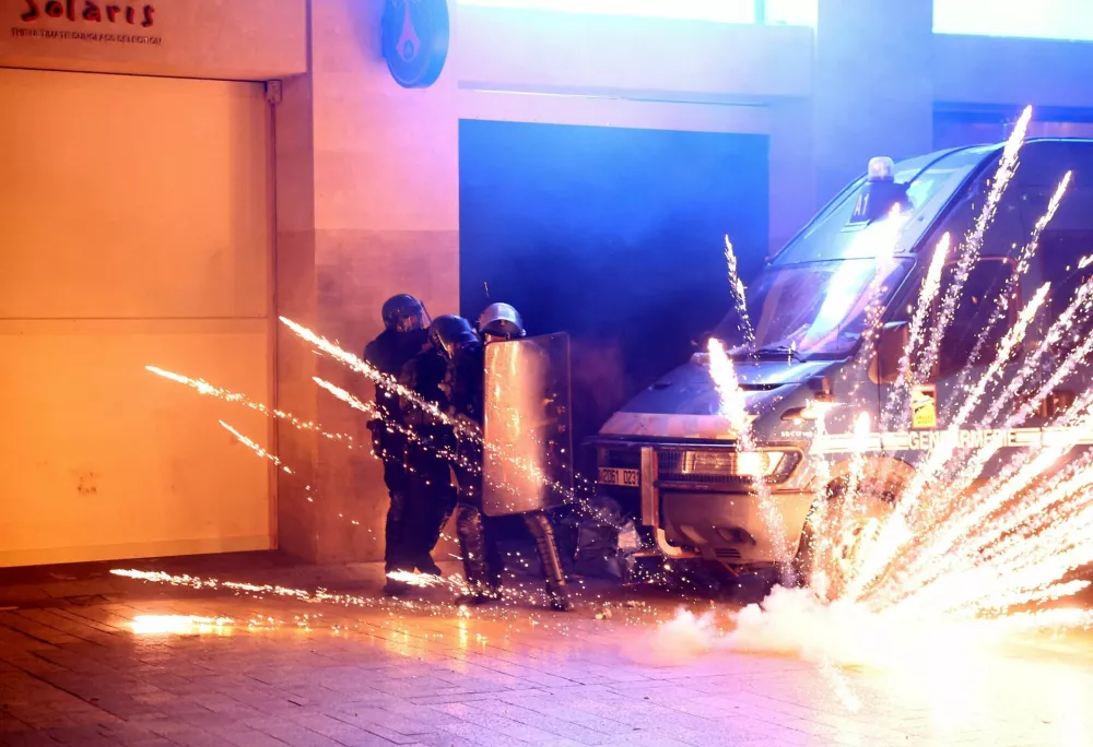 Soccer Football - Champions League - Final - Paris St Germain fans gather in Paris - Paris, France - May 31, 2025 Police officers protect themselves from a flare on the Champs Elysees avenue after Paris St Germain won the Champions League REUTERS/Abdul Saboor   TPX IMAGES OF THE DAY
