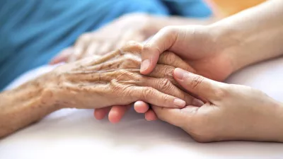 Woman holding senior woman's hand on bed / Foto: Pharrel Wiliams