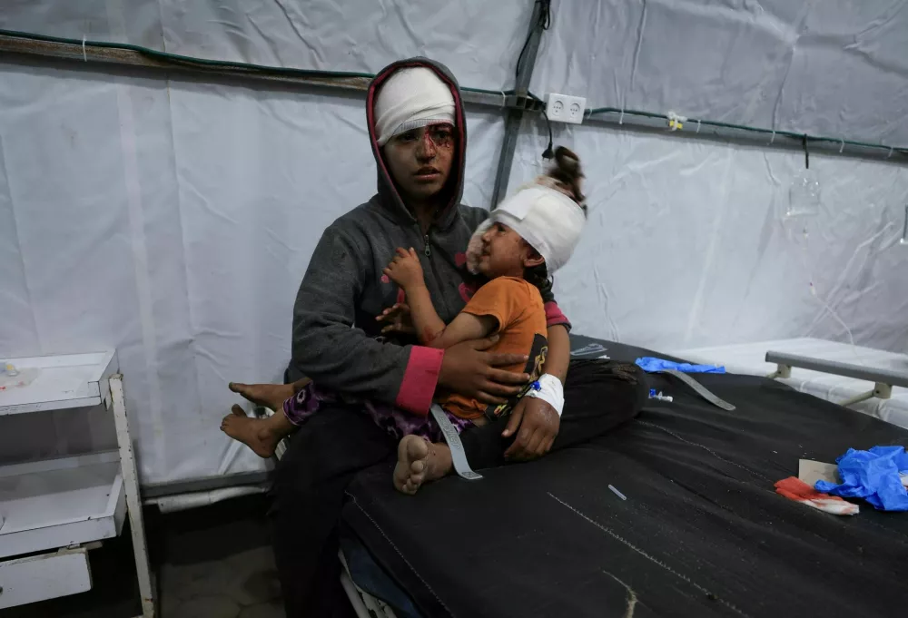 SENSITIVE MATERIAL. THIS IMAGE MAY OFFEND OR DISTURB A wounded Palestinian sits while holding a child, at Al-Ahli Arab Baptist hospital, following an Israeli strike, in Gaza City, May 26, 2025. REUTERS/Dawoud Abu Alkas