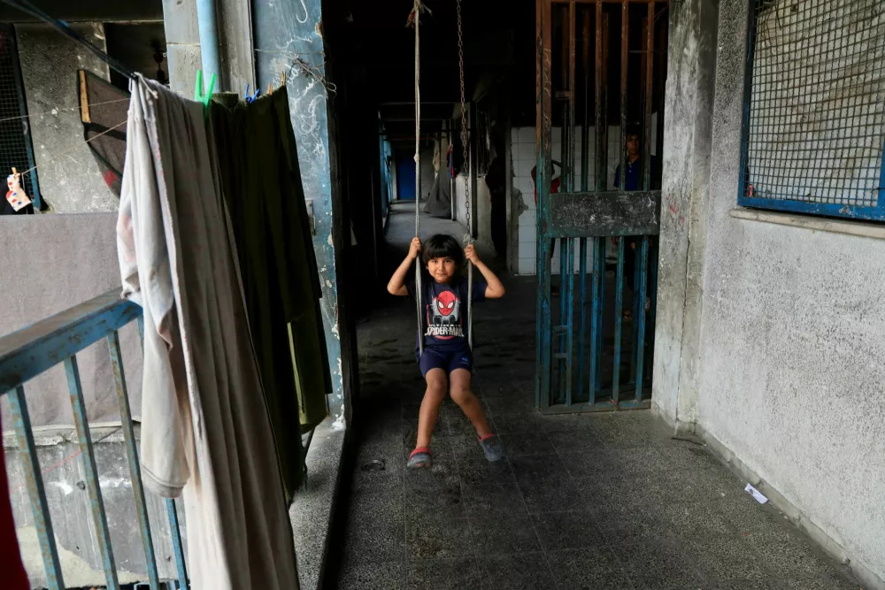 A Palestinians child uses a swing at a UNRWA school, in Khan Younis in the southern Gaza Strip, May 28, 2025. REUTERS/Hatem Khaled