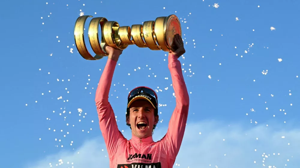 Cycling - Giro d'Italia - Stage 21 - Rome to Rome - Italy - June 1, 2025 Team Visma | Lease a Bike's Simon Yates celebrates with a trophy on the podium after winning the Giro d'Italia REUTERS/Jennifer Lorenzini   TPX IMAGES OF THE DAY