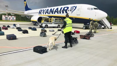 FILE - In this May 23, 2021, file photo provided by ONLINER.BY, security use a dog to check the luggage of passengers on the Ryanair jet that carried opposition figure Raman Pratasevich, traveling from Athens to Vilnius, Lithuania. The plane was diverted to Minsk, Belarus, after Belarusian flight controllers told the crew that there was a bomb threat against the plane. Pratasevich, who ran a channel on a messaging app used to organize demonstrations against authoritarian President Alexander Lukashenko, left his homeland in 2019 to try to escape the reach of the Belarusian KGB. Pratasevich was arrested upon landing in Minsk and faces 15 years in prison on charges of inciting disturbances. ď&raquo;żď&raquo;ż(ONLINER.BY via AP)