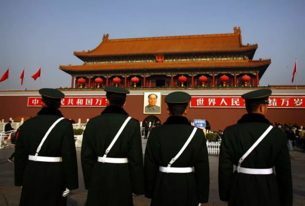 Paramilitary policemen stand guard in front of the giant portrait of former Chinese Chairman Mao Zedong at Beijing's Tiananmen Square November 15, 2012. China's ruling Communist Party unveiled its new leadership line-up on Thursday to steer the world's second-largest economy for the next five years, with Vice President Xi Jinping taking over from outgoing President Hu Jintao as party chief. REUTERS/David Gray (CHINA - Tags: POLITICS CRIME LAW MILITARY)