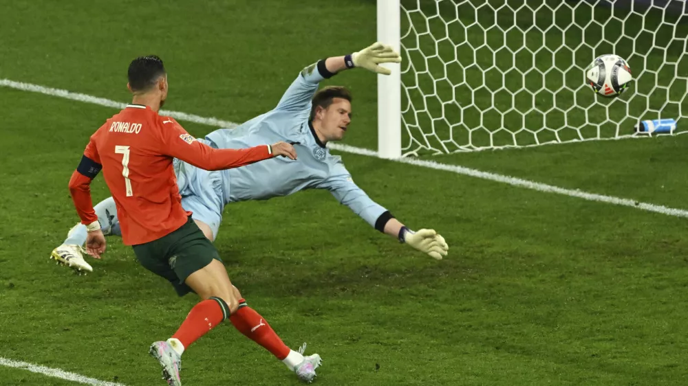 Portugal's Cristiano Ronaldo, left, scores his side's second goal during the Nations League semifinal soccer match between Portugal and Germany in Munich, Germany, Wednesday, June 4, 2025. (Peter Kneffel/dpa via AP)