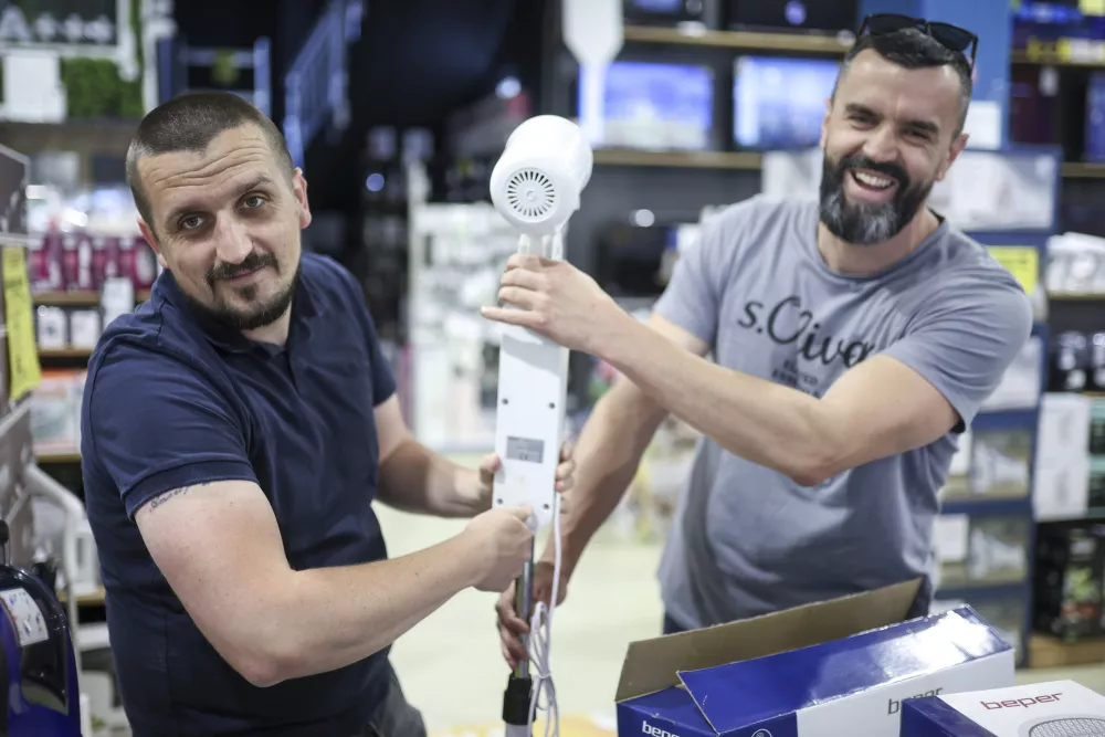 Owners of "Only fools and horses ltd." home appliance store, Tarik Fatic, left, and his brother Mirnes assemble a fan in Hadzici, suburb of Sarajevo, Bosnia, Wednesday, June 4, 2025. (AP Photo/Armin Durgut)