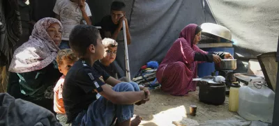 Tahreer Abu Jazar, 36, right, prepares an Eid al-Adha meal for her family inside their tent at a camp for displaced Palestinians in Mawasi Khan Younis, Gaza Strip, on Friday, June 6, 2025. (AP Photo/Abdel Kareem Hana)