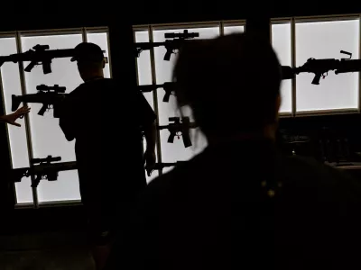 FILE PHOTO: A man looks at an AR-15 rife at an exhibition booth during the National Rifle Association (NRA) annual convention in Dallas, Texas, U.S., May 18, 2024. REUTERS/Carlos Barria/File Photo