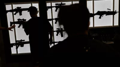 FILE PHOTO: A man looks at an AR-15 rife at an exhibition booth during the National Rifle Association (NRA) annual convention in Dallas, Texas, U.S., May 18, 2024. REUTERS/Carlos Barria/File Photo