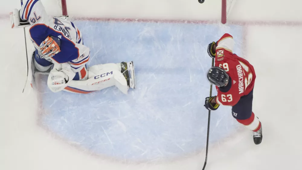 Florida Panthers center Brad Marchand (63) watches as a shot by center Carter Verhaeghe enters the goal against Edmonton Oilers goaltender Stuart Skinner (74) during the first period of Game 3 of the NHL Stanley Cup final Monday, June 9, 2025, in Sunrise, Fla. (AP Photo/Lynne Sladky)