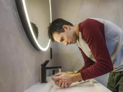 Young man carefully washes his hands in a modern bathroom, promoting hygiene, health, and responsible daily habits in a clean and organized environment. High quality photo / Foto: Stockseller_ukr