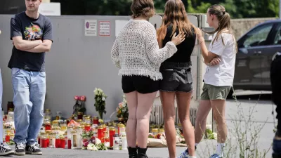 Students stand outside a school where a former student opened fire the day before fatally wounding several people and injuring many others before taking his own life, Graz, Austria, Wednesday, June 11, 2025. (AP Photo/Darko Bandic)