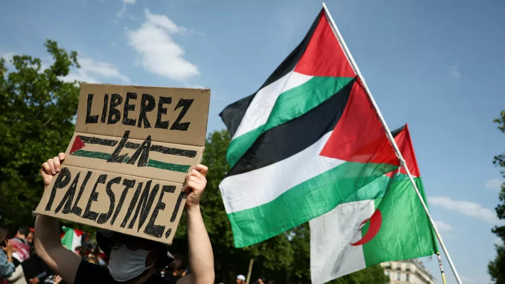 A man holds a placard reading "Free Palestine" during a demonstration, to protest after Israeli forces seize the British-flagged yacht, Madleen, which is operated by the pro-Palestinian Freedom Flotilla Coalition, was aiming to deliver a symbolic amount of aid to Gaza later on Monday and raise international awareness of the humanitarian crisis there, at the Place de la Republique in Paris, France June 9, 2025. REUTERS/Sarah Meyssonnier